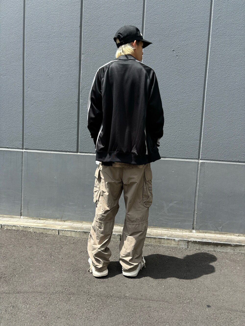 ブラック系のTシャツ/カットソー、ベージュ系のカーゴパンツ、ブラック系のジャケット/アウターを着用したメンズの夏コーディネートの2枚目の写真