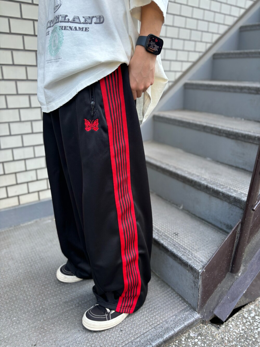 ホワイト系のTシャツ/カットソー、ブラック系のパンツを着用したメンズの夏コーディネートの3枚目の写真