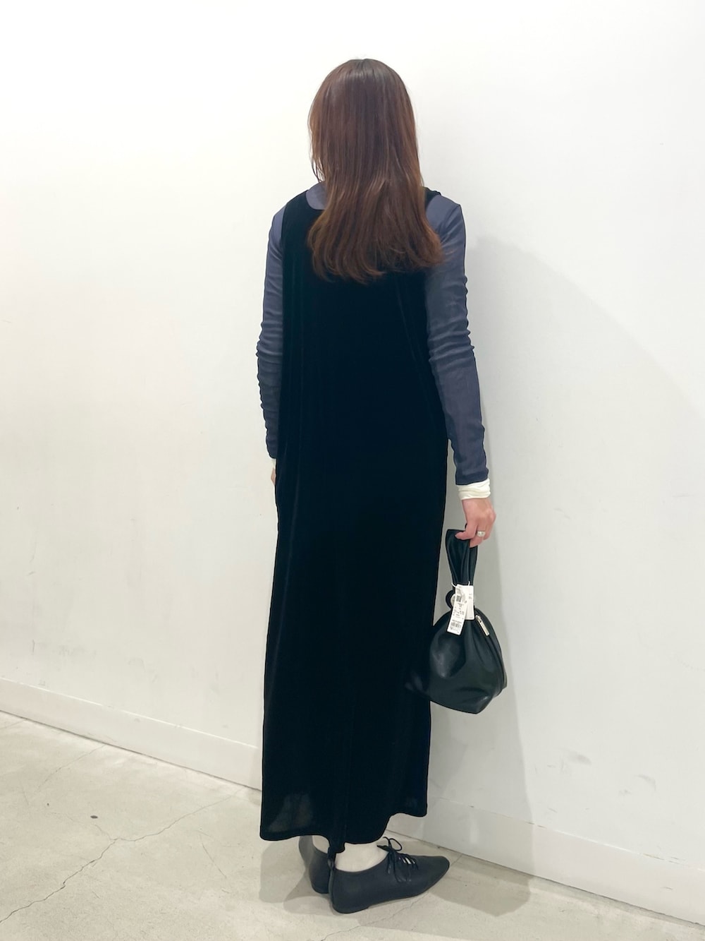 ブラック系のその他シューズ、ブラック系のワンピース、ブラック系のハンドバッグを着用したレディースの冬コーディネートの3枚目の写真