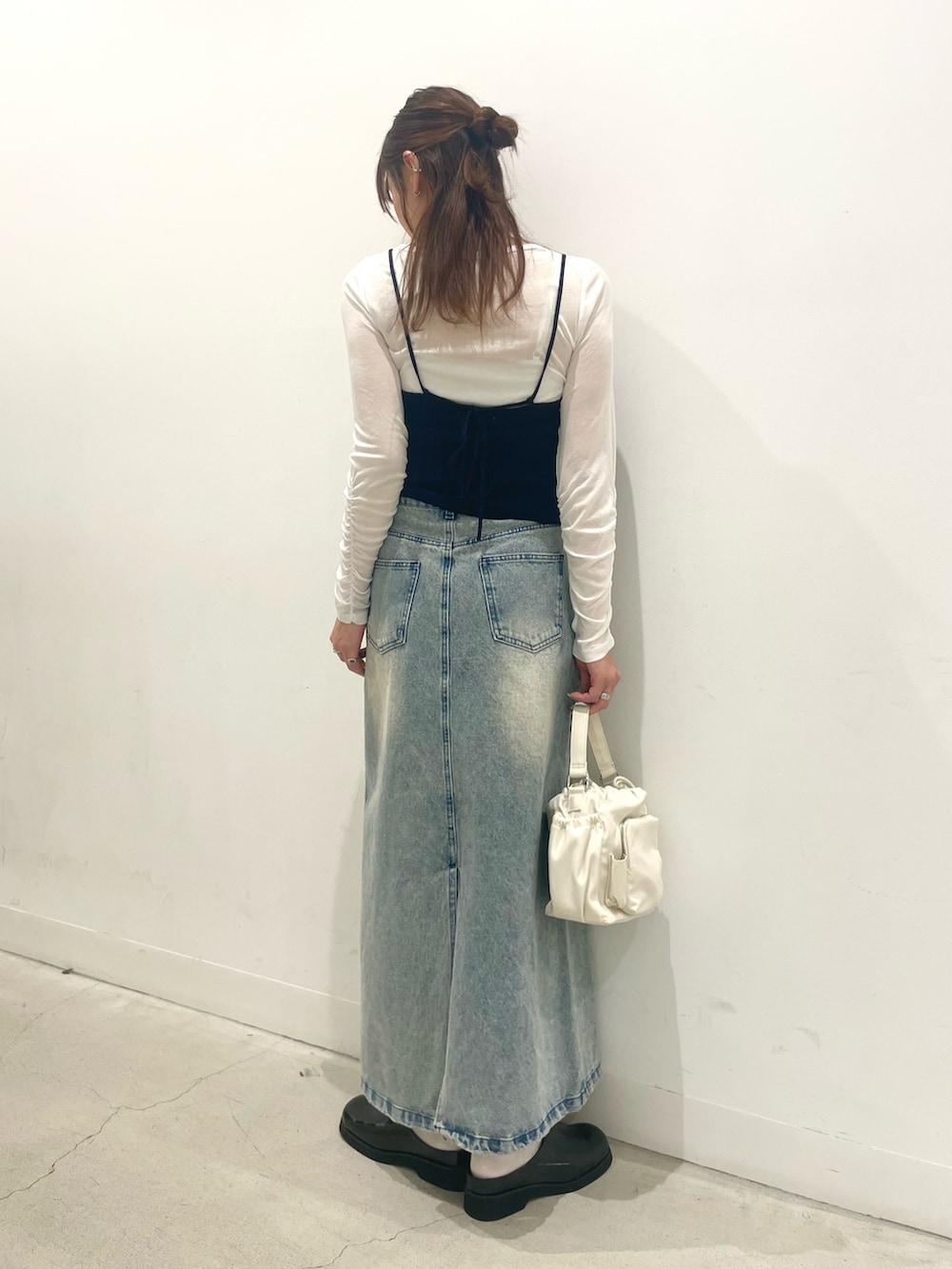 ブラック系のサンダル、ホワイト系のハンドバッグ、ブルー系のスカートを着用したレディースの春コーディネートの3枚目の写真