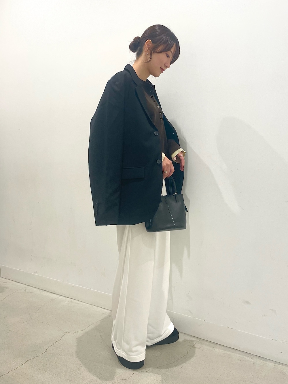 ブラック系のブーツ、ブラック系のショルダーバッグ、ブラウン系のニット/セーターを着用したレディースの秋コーディネートの2枚目の写真