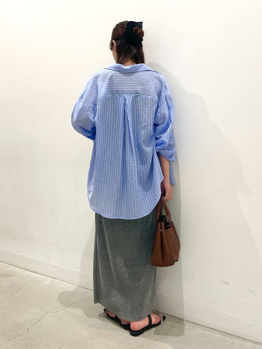 ブラック系のサンダル、グレー系のスカート、ブラック系のキャミソールを着用したレディースの夏コーディネートの3枚目の写真