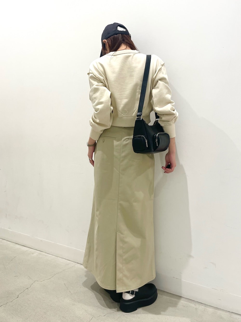 ブラック系のその他シューズ、ブラック系のショルダーバッグ、ベージュ系のスカートを着用したレディースの冬コーディネートの3枚目の写真