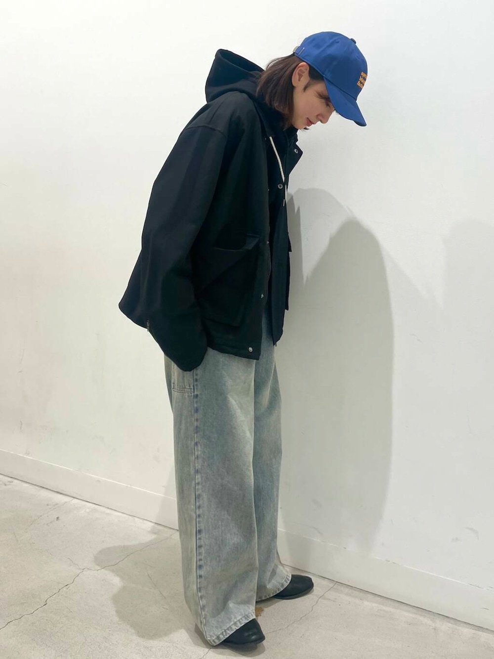 ブラック系のブーツ、ブルー系のデニムパンツ、シルバー系のショルダーバッグを着用したレディースの冬コーディネートの2枚目の写真