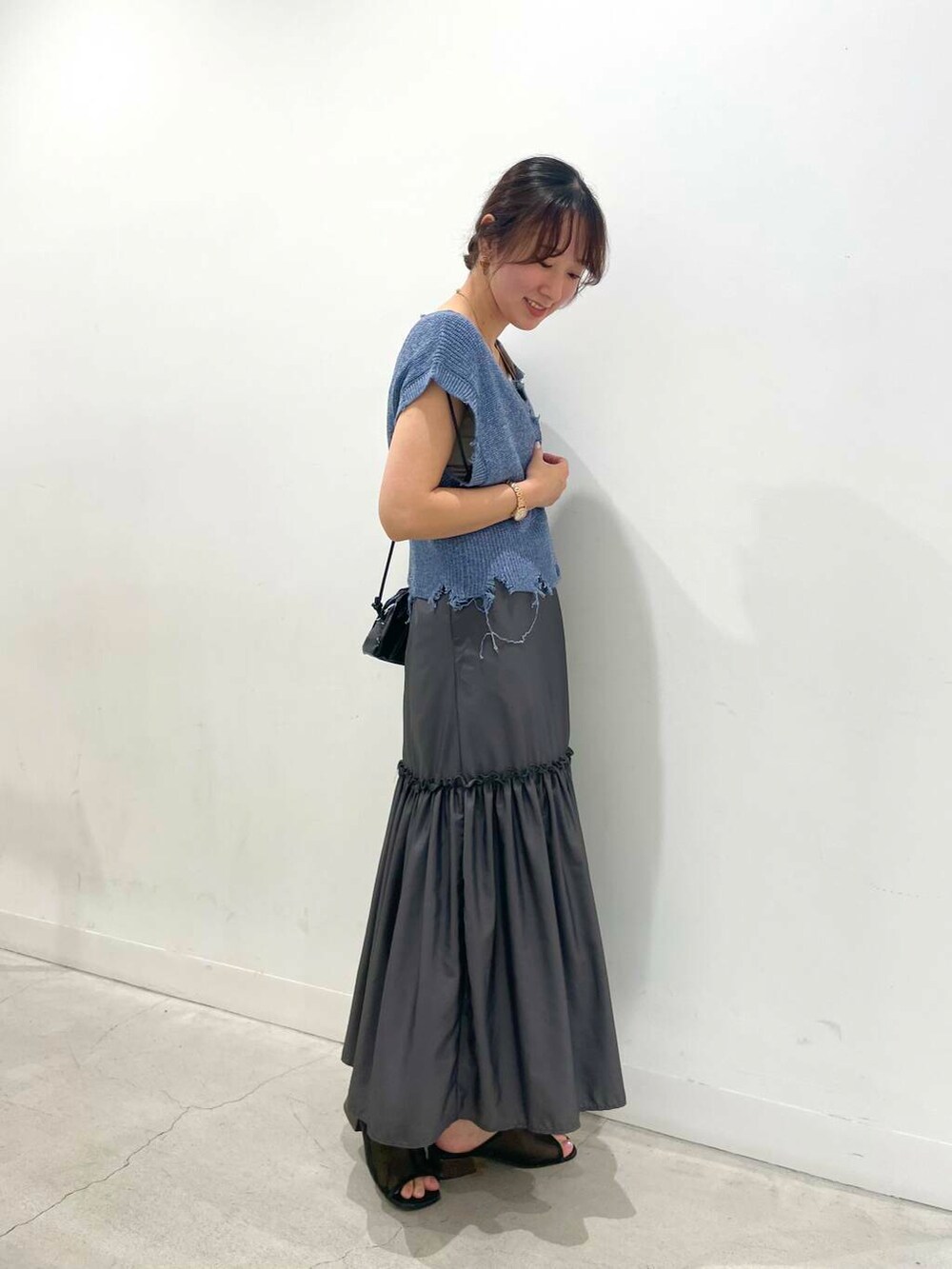 ブラック系のショルダーバッグ、ベージュ系のキャミソール、グレー系のワンピースを着用したレディースの夏コーディネートの2枚目の写真