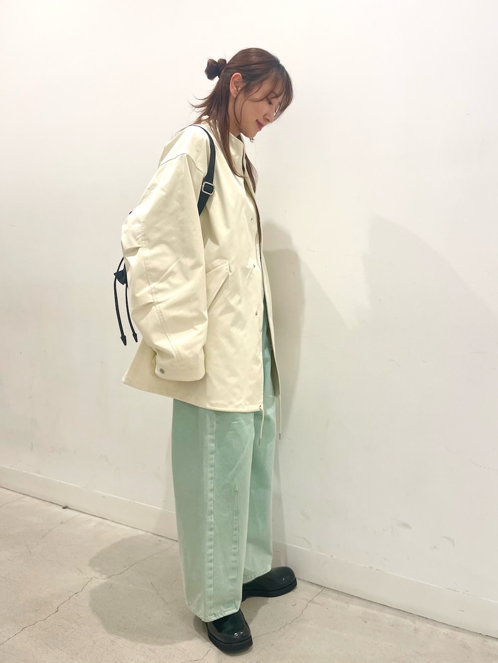 ブラック系のサンダル、グリーン系のデニムパンツ、ホワイト系のTシャツ/カットソーを着用したレディースの春コーディネートの3枚目の写真