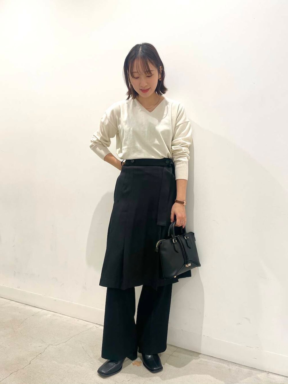 ブラック系のその他パンツ、ブラック系のボストンバッグ、ブラック系のブーツを着用したレディースの秋コーディネートの4枚目の写真