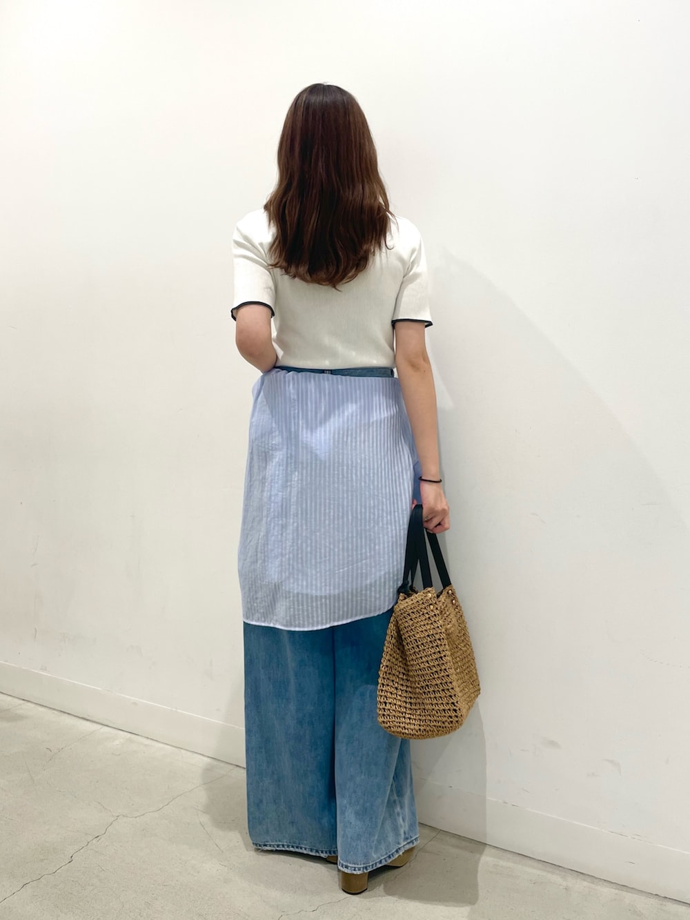 ベージュ系のサンダル、イエロー系のかごバッグ、ブルー系のデニムパンツを着用したレディースの夏コーディネートの3枚目の写真