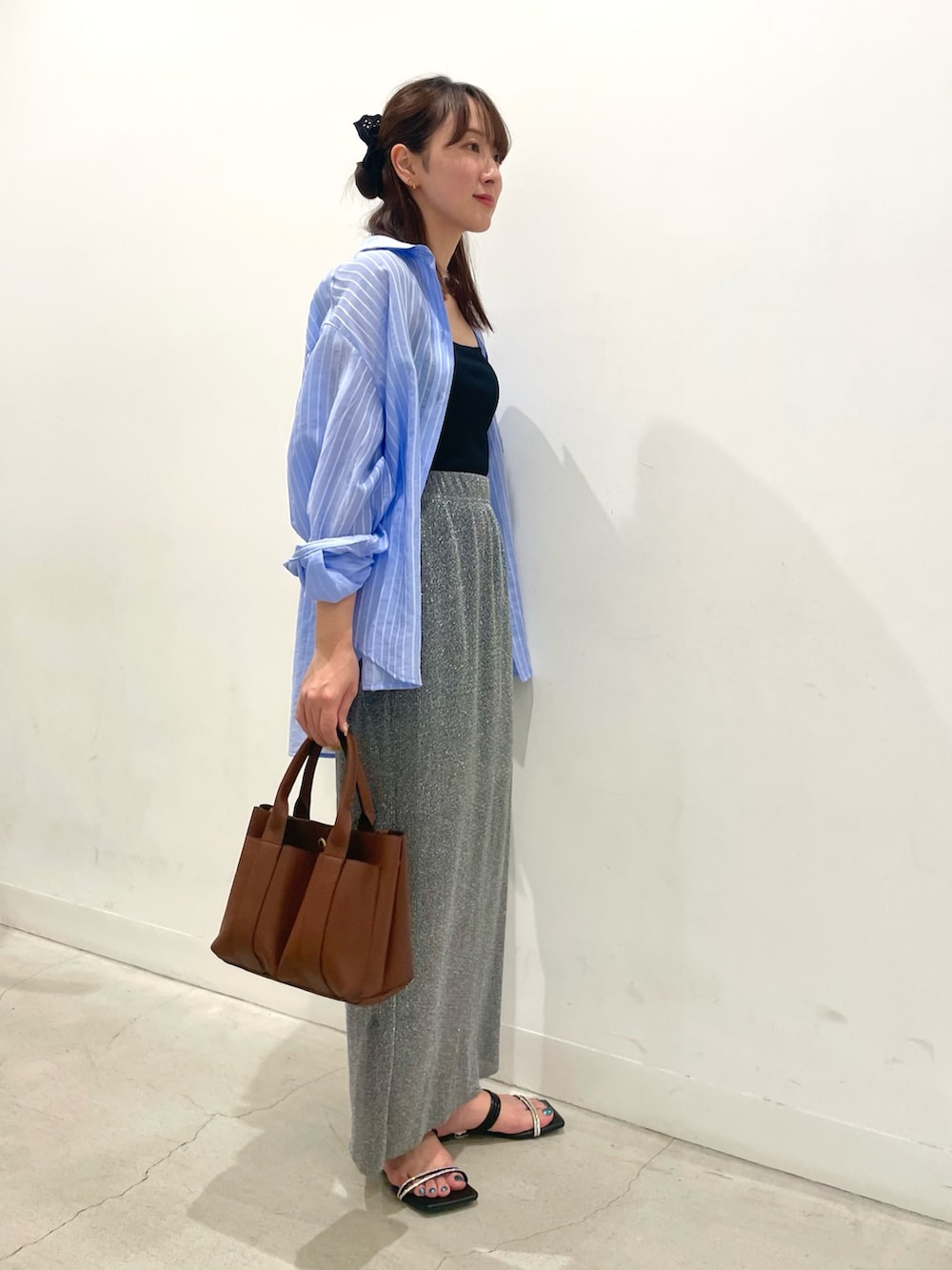 ブラック系のサンダル、グレー系のスカート、ブラック系のキャミソールを着用したレディースの夏コーディネートの2枚目の写真