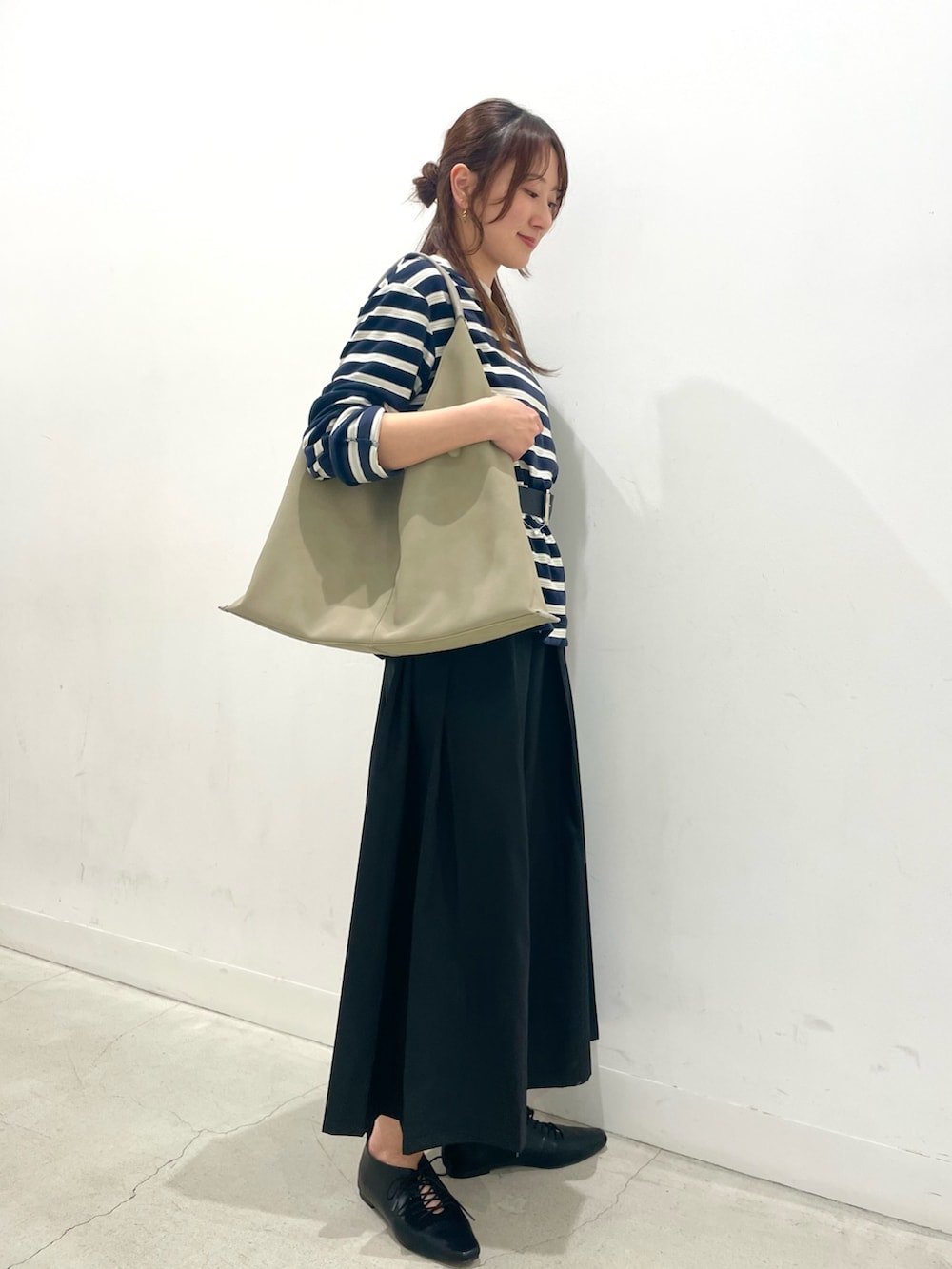 ブラック系のその他シューズ、グレー系のトートバッグ、ブラック系のスカートを着用したレディースの春コーディネートの2枚目の写真