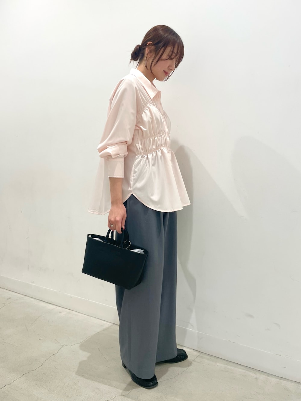 ブラック系のローファー、ブラック系のトートバッグ、グレー系のスラックスを着用したレディースの冬コーディネートの2枚目の写真