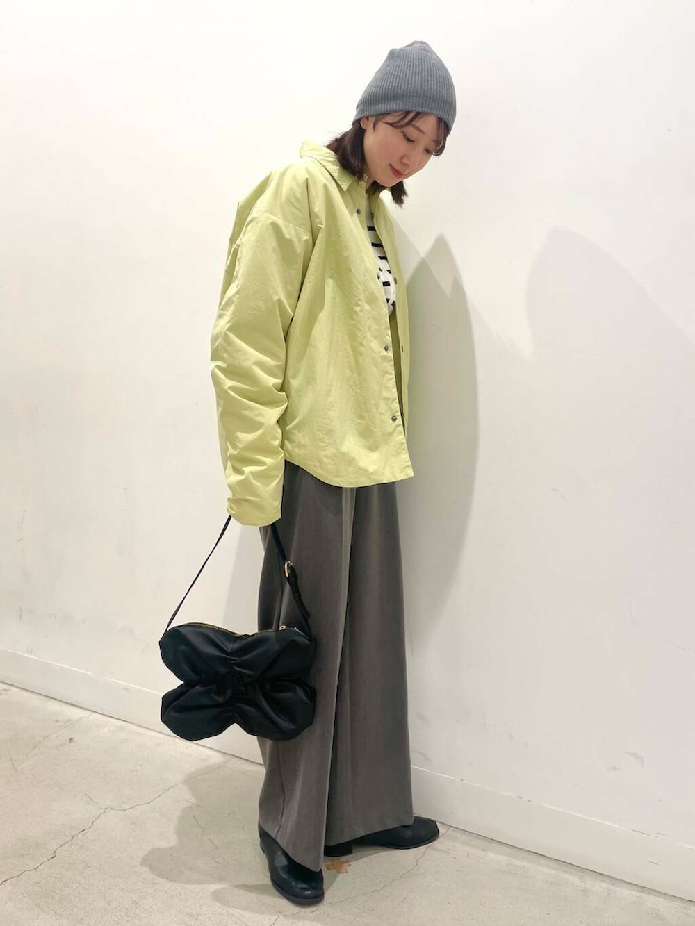 グレー系のその他パンツ、ブラック系のハンドバッグ、ブラック系のブーツを着用したレディースの冬コーディネートの2枚目の写真