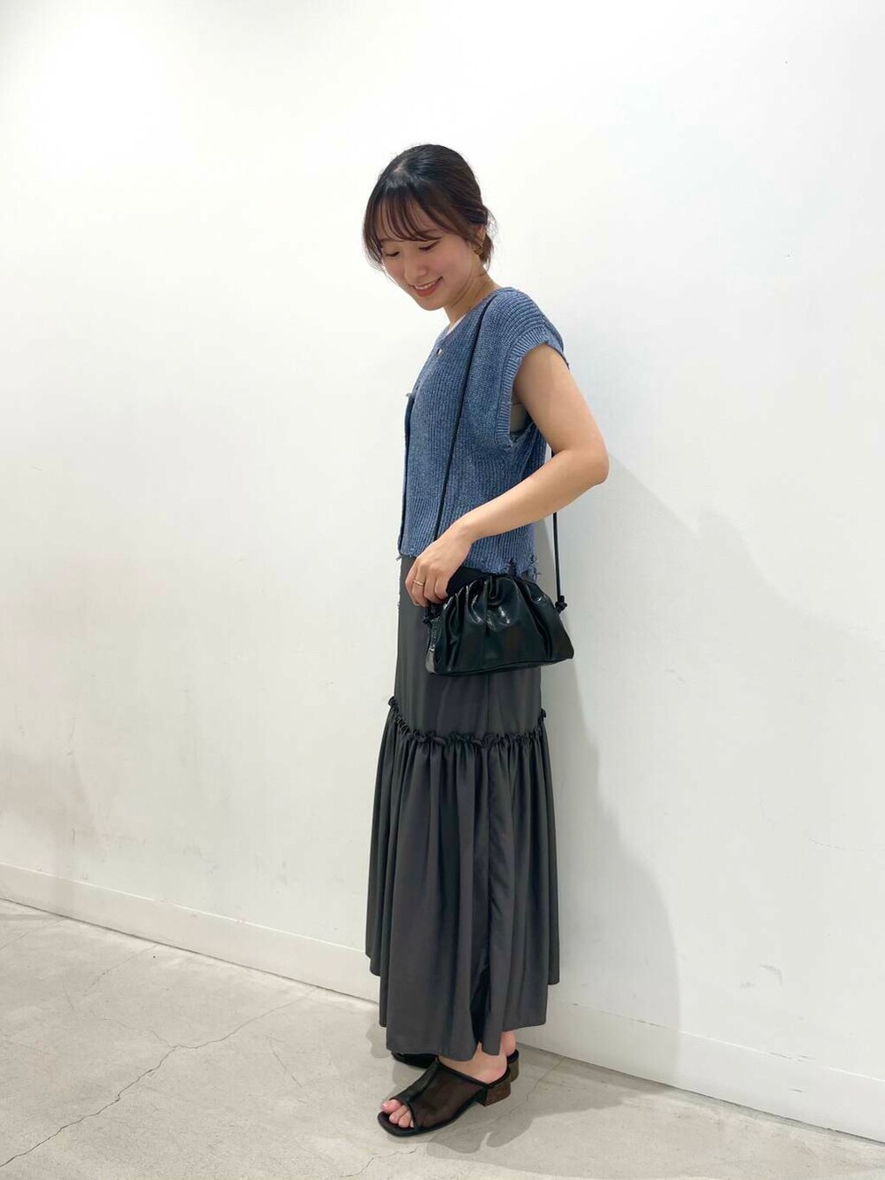 ブラック系のショルダーバッグ、ベージュ系のキャミソール、グレー系のワンピースを着用したレディースの夏コーディネートの4枚目の写真