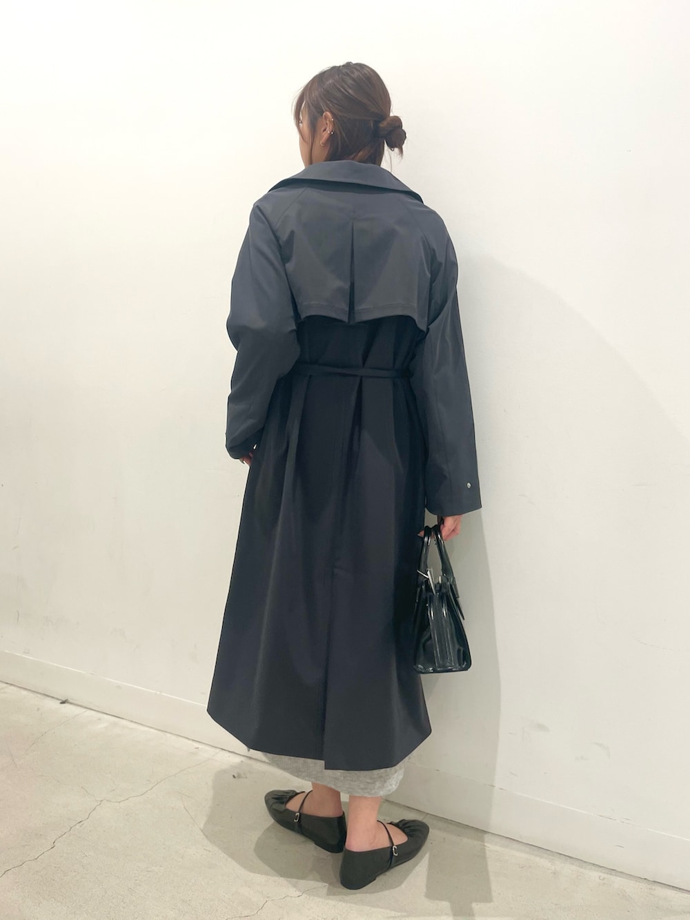 ブラック系のパンプス、ブラック系のボストンバッグ、グレー系のワンピースを着用したレディースの春コーディネートの3枚目の写真