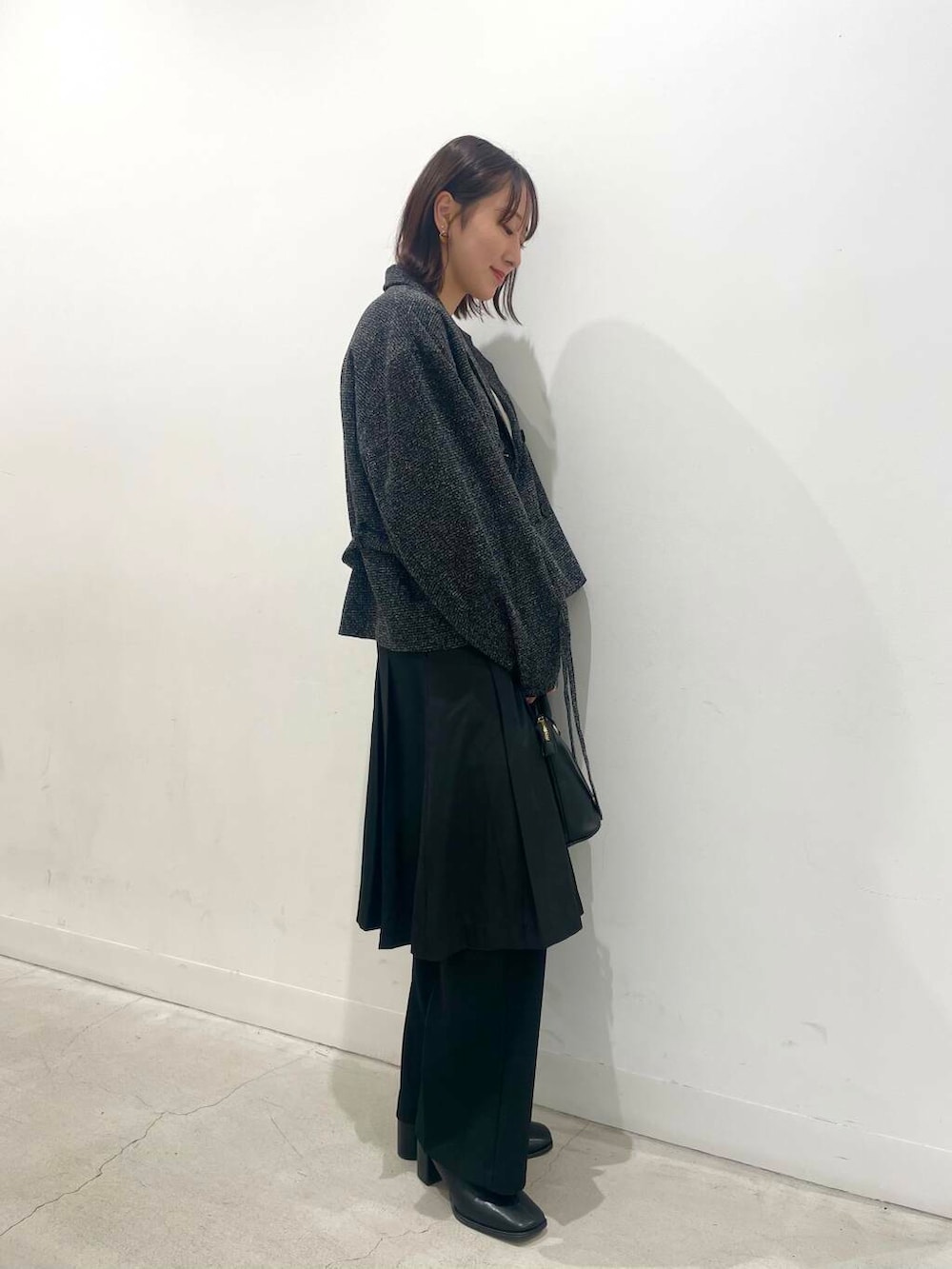 ブラック系のその他パンツ、ブラック系のボストンバッグ、ブラック系のブーツを着用したレディースの秋コーディネートの2枚目の写真