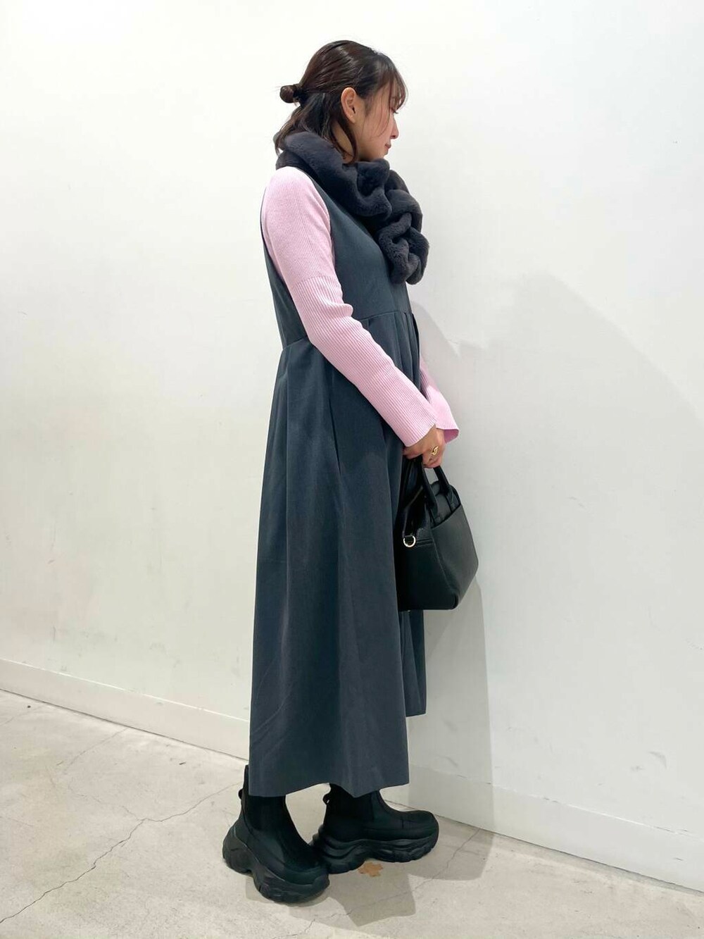 ブラック系のボストンバッグ、グレー系のワンピース、ブラック系のブーツを着用したレディースの冬コーディネートの3枚目の写真