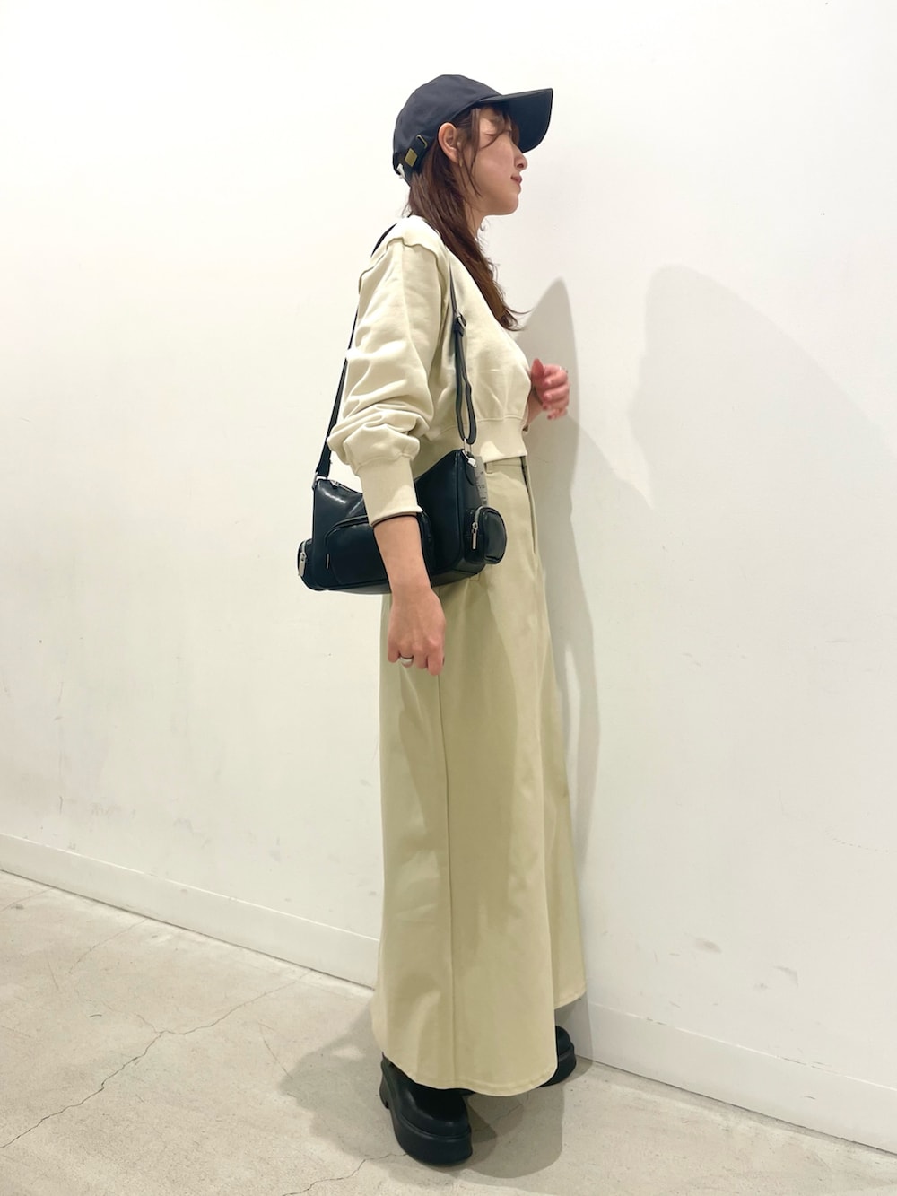 ブラック系のその他シューズ、ブラック系のショルダーバッグ、ベージュ系のスカートを着用したレディースの冬コーディネートの2枚目の写真