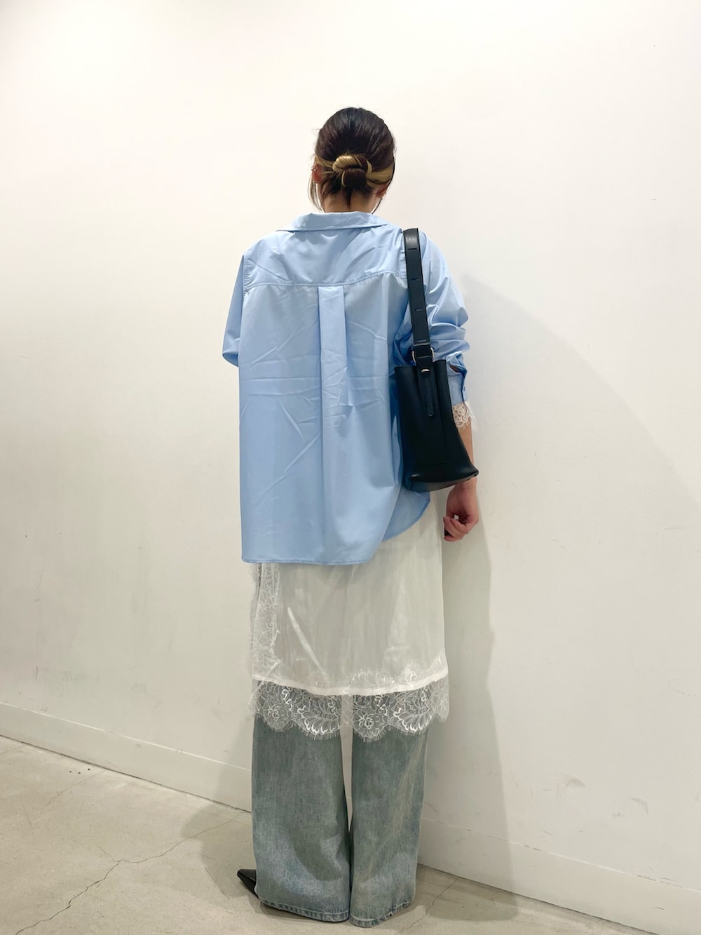 ブラック系のパンプス、ブラック系のショルダーバッグ、ブルー系のデニムパンツを着用したレディースの秋コーディネートの3枚目の写真