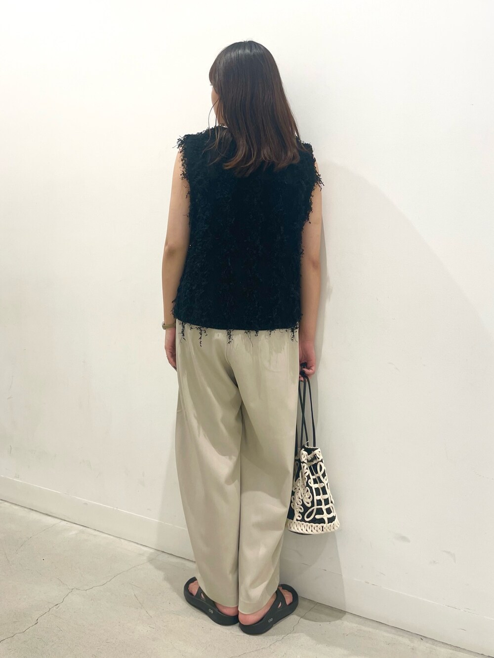 ベージュ系のその他パンツ、ブラック系のベスト、ブラック系のハンドバッグを着用したレディースの秋コーディネートの3枚目の写真