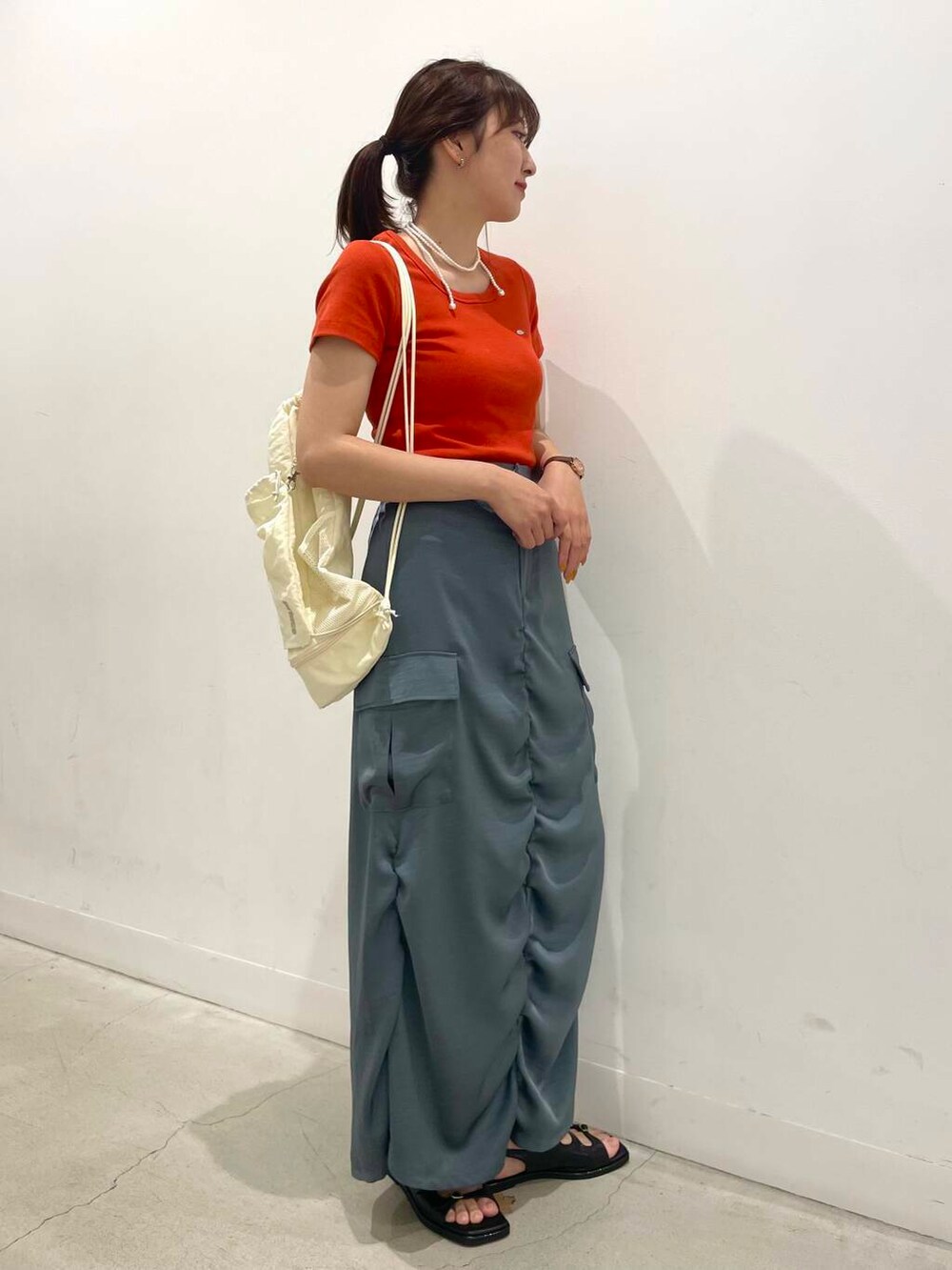 ホワイト系のショルダーバッグ、ブラック系のサンダル、レッド系のTシャツ/カットソーを着用したレディースの夏コーディネートの2枚目の写真