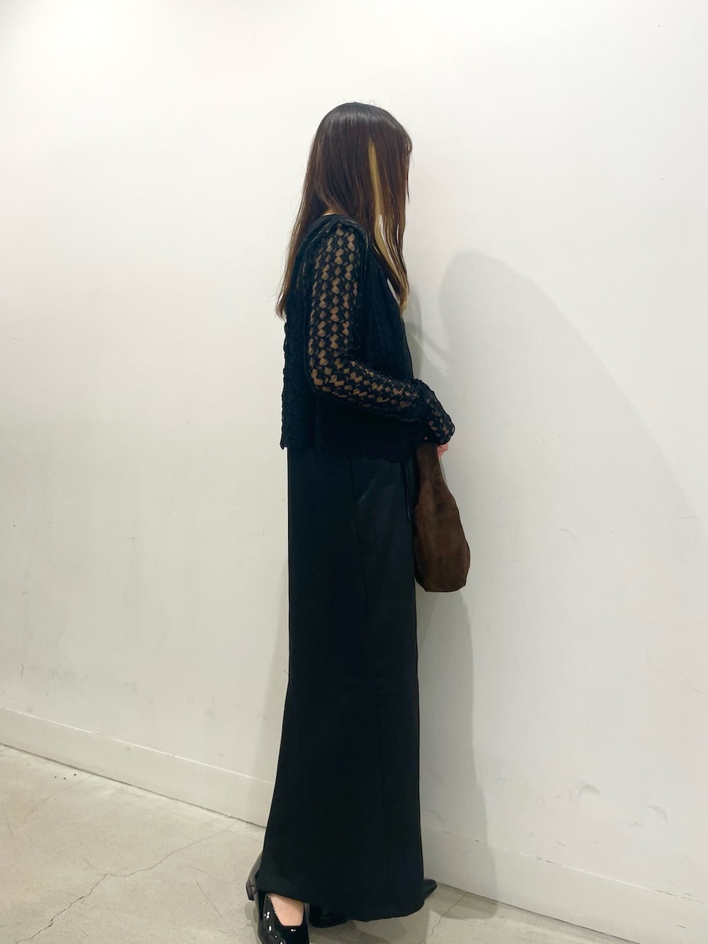 ブラック系のパンプス、ブラウン系のハンドバッグ、ブラック系のワンピースを着用したレディースの秋コーディネートの2枚目の写真