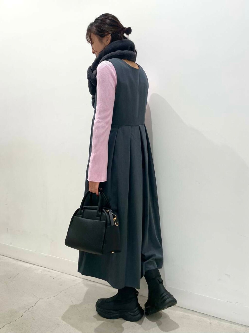 ブラック系のボストンバッグ、グレー系のワンピース、ブラック系のブーツを着用したレディースの冬コーディネートの4枚目の写真