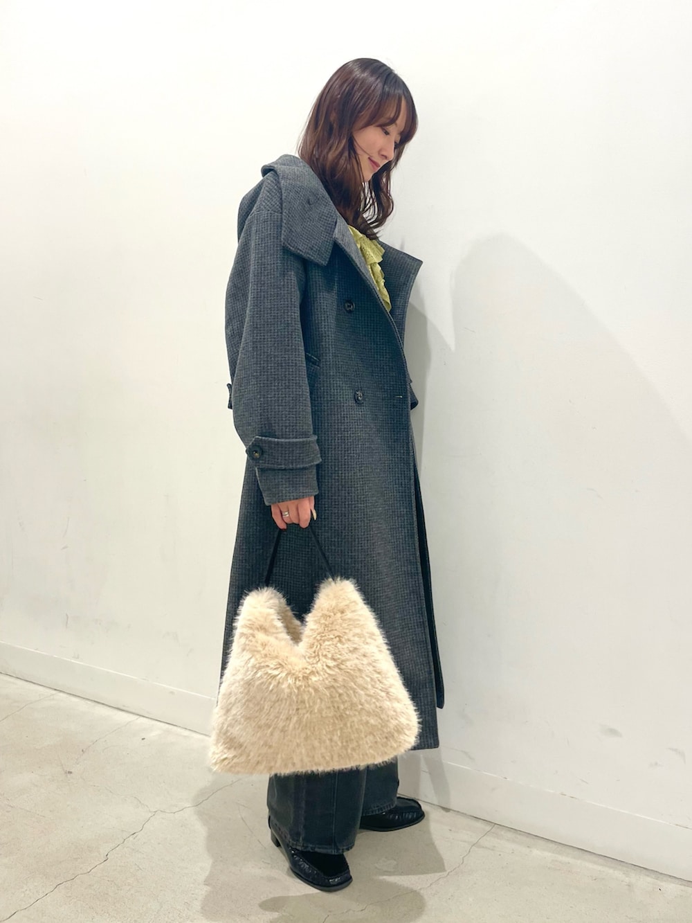 ブラック系のローファー、ホワイト系のハンドバッグ、グレー系のデニムパンツを着用したレディースの秋コーディネートの3枚目の写真