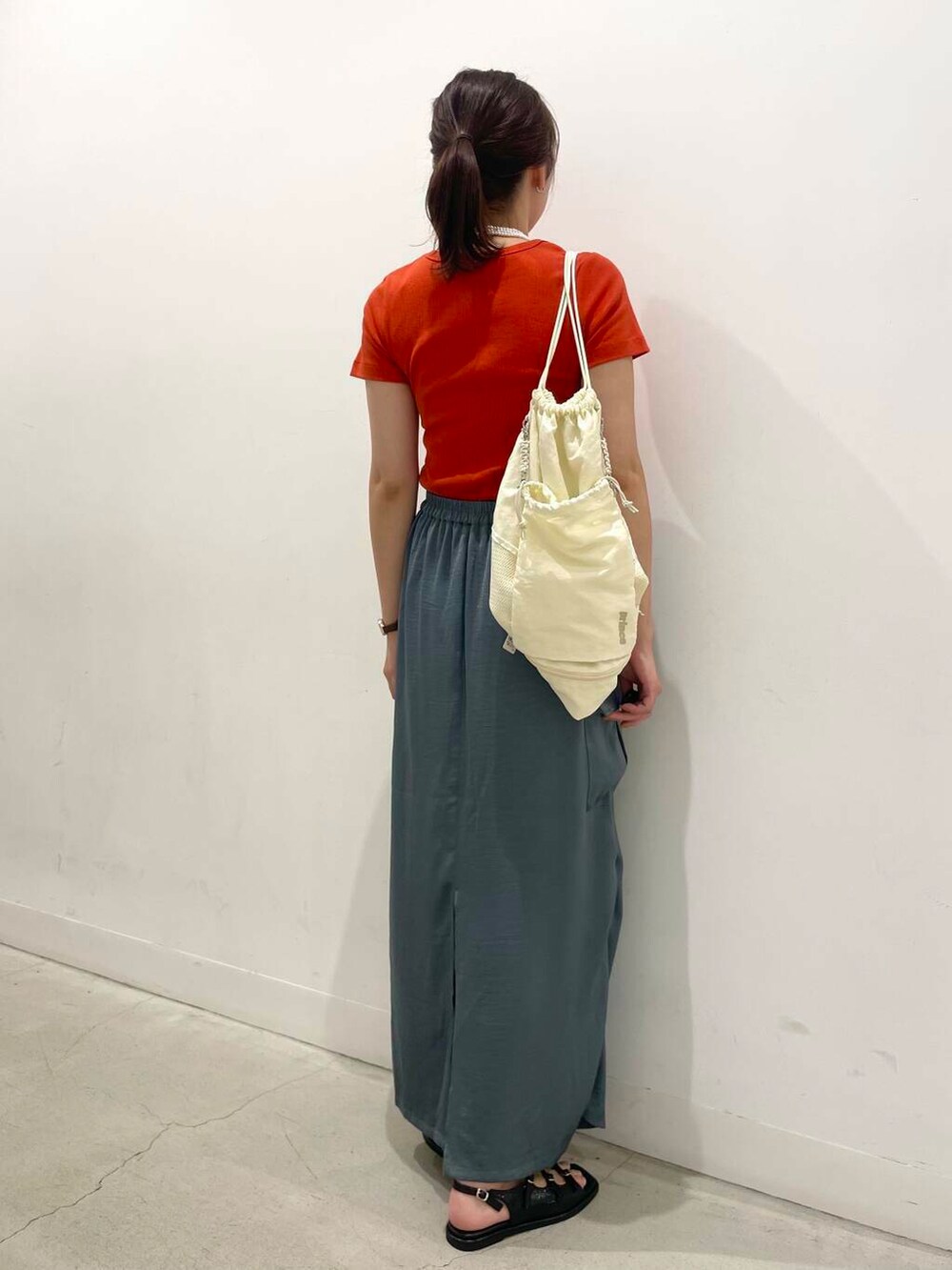 ホワイト系のショルダーバッグ、ブラック系のサンダル、レッド系のTシャツ/カットソーを着用したレディースの夏コーディネートの3枚目の写真