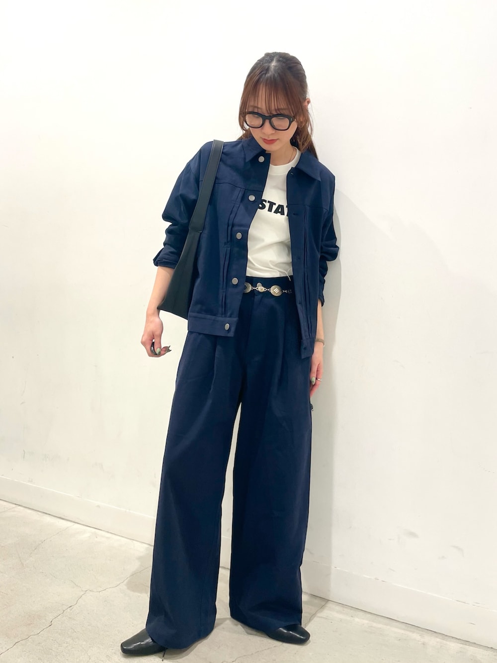 ブラック系のその他シューズ、ブラック系のハンドバッグ、ブルー系のその他パンツを着用したレディースの春コーディネートの2枚目の写真