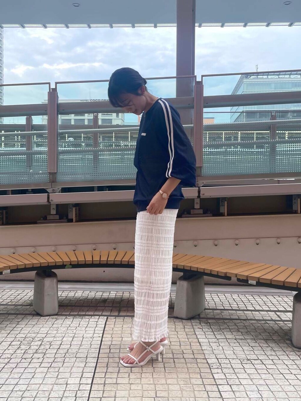 ホワイト系のサンダル、ホワイト系のスカート、ブルー系のTシャツ/カットソーを着用したレディースの夏コーディネートの4枚目の写真