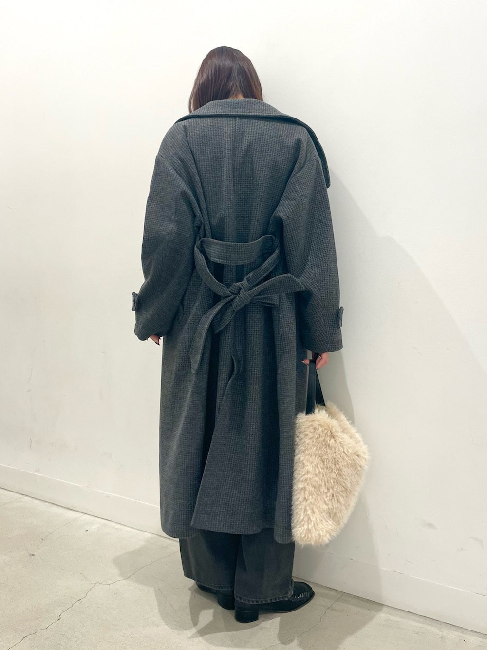 ブラック系のローファー、ホワイト系のハンドバッグ、グレー系のデニムパンツを着用したレディースの秋コーディネートの4枚目の写真