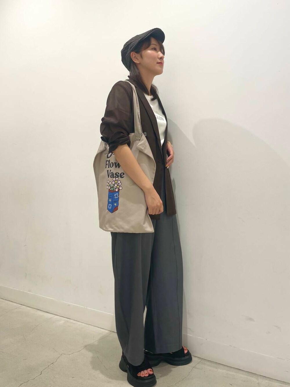 ブラック系のサンダル、その他のTシャツ/カットソー、グレー系のトートバッグを着用したレディースの夏コーディネートの2枚目の写真