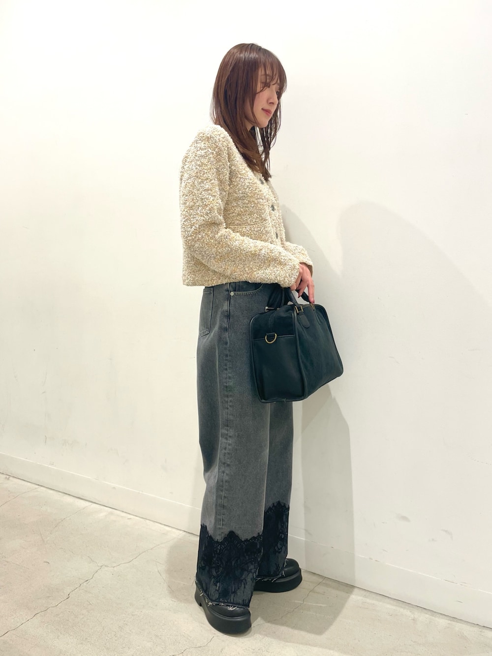 ブラック系のその他シューズ、グレー系のボストンバッグ、グレー系のデニムパンツを着用したレディースの冬コーディネートの2枚目の写真