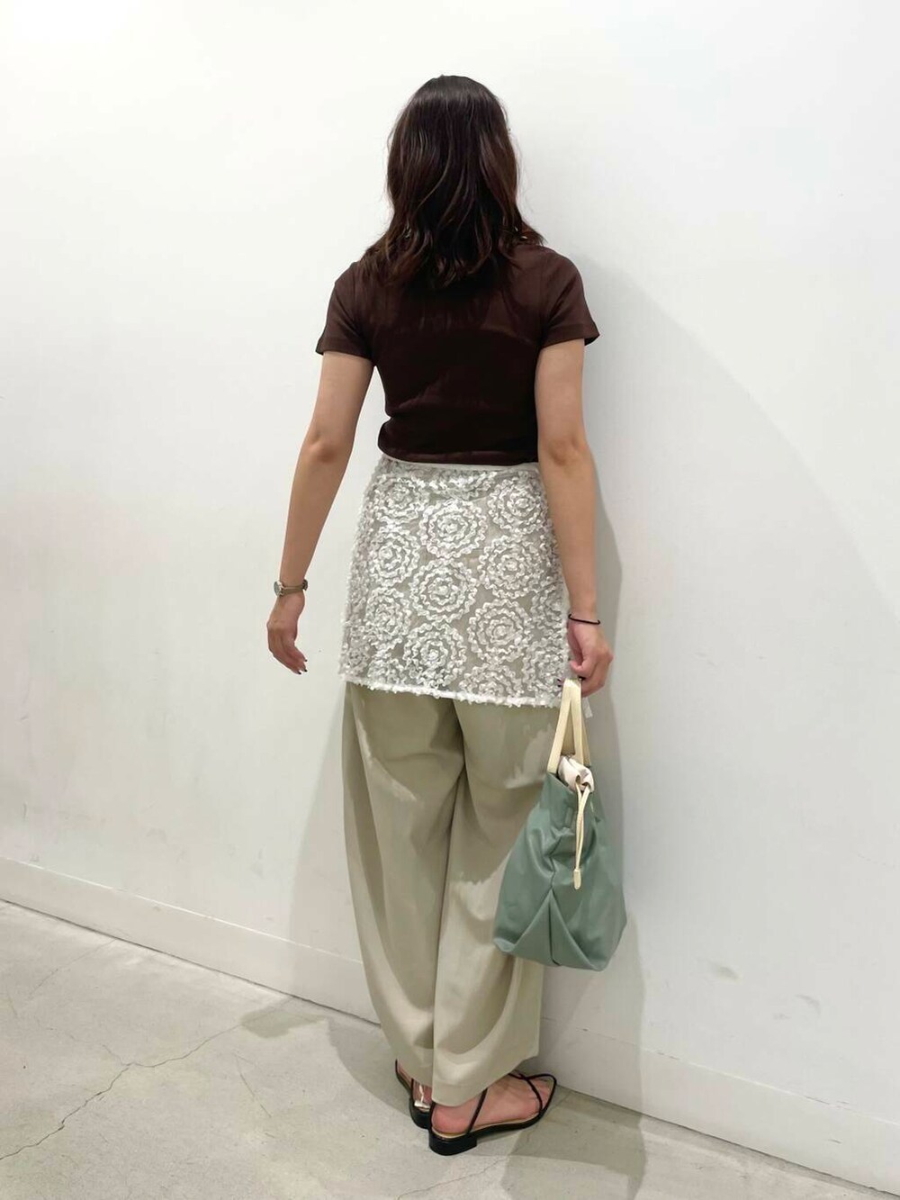 ブラック系のサンダル、ホワイト系のスカート、ベージュ系のその他パンツを着用したレディースの夏コーディネートの3枚目の写真