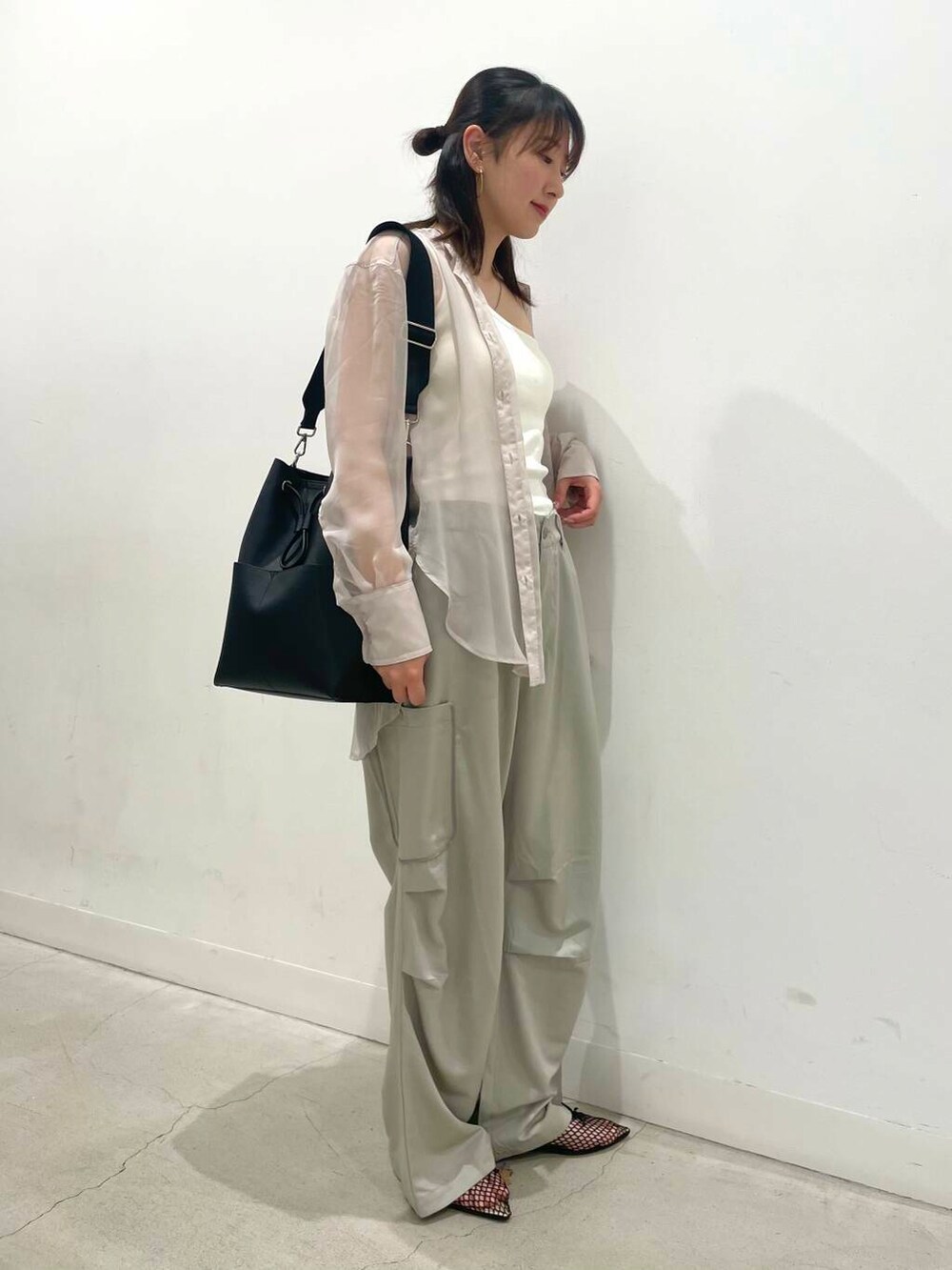 ブラック系のバレエシューズ、ブラック系のショルダーバッグ、ピンク系のシャツ/ブラウスを着用したレディースの春コーディネートの2枚目の写真