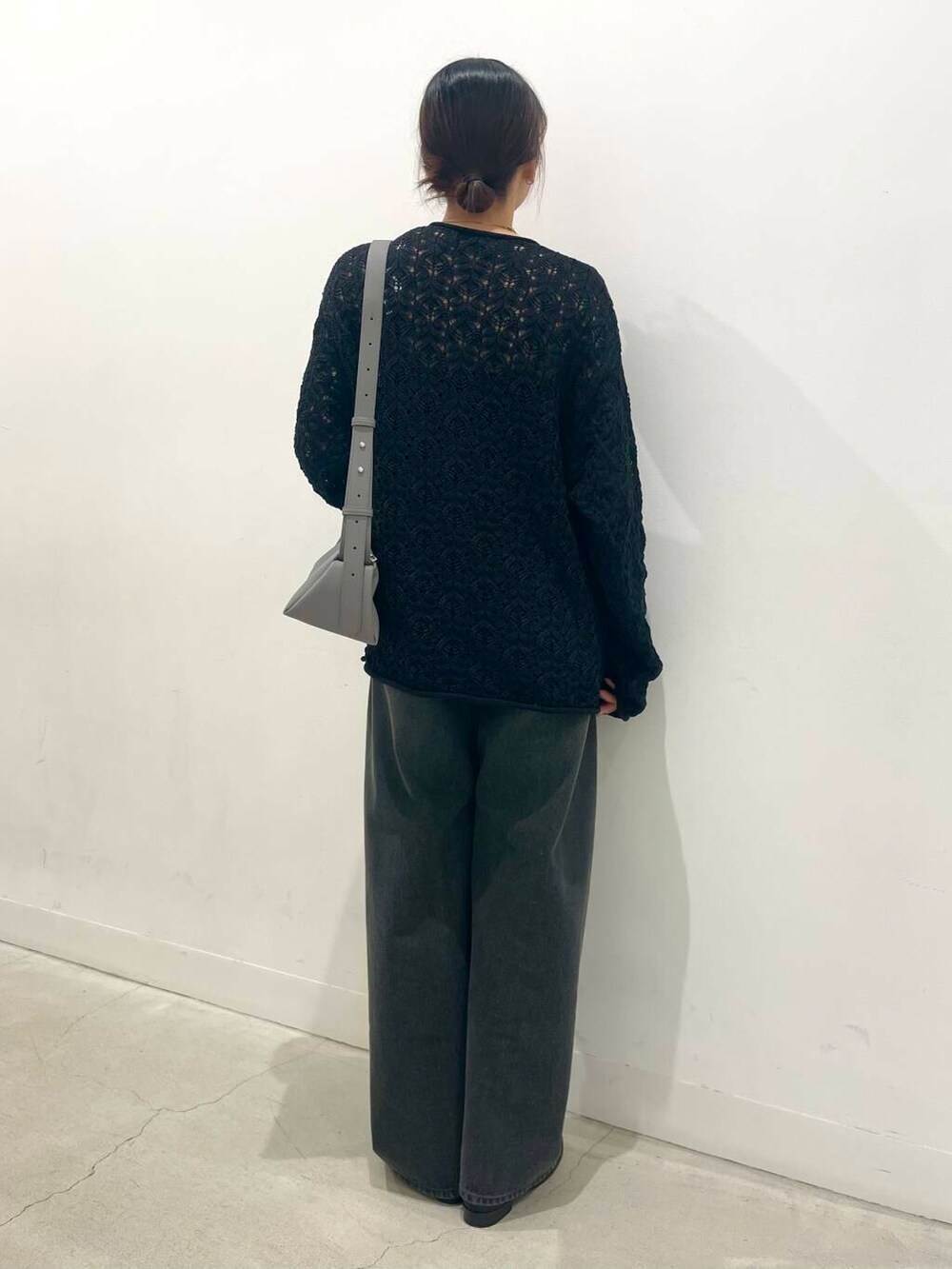 グレー系のショルダーバッグ、ブラック系のカーディガン/ボレロ、ブラック系のローファーを着用したレディースの春コーディネートの3枚目の写真