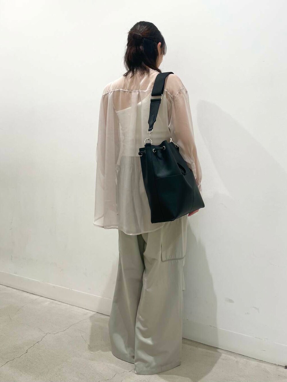 ブラック系のバレエシューズ、ブラック系のショルダーバッグ、ピンク系のシャツ/ブラウスを着用したレディースの春コーディネートの3枚目の写真