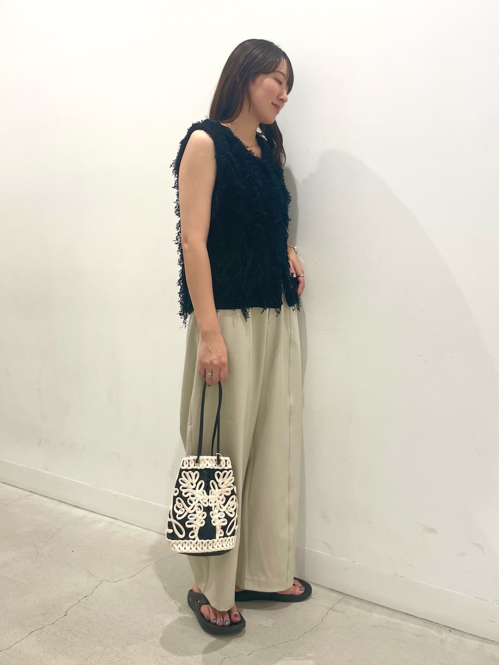 ベージュ系のその他パンツ、ブラック系のベスト、ブラック系のハンドバッグを着用したレディースの秋コーディネートの2枚目の写真