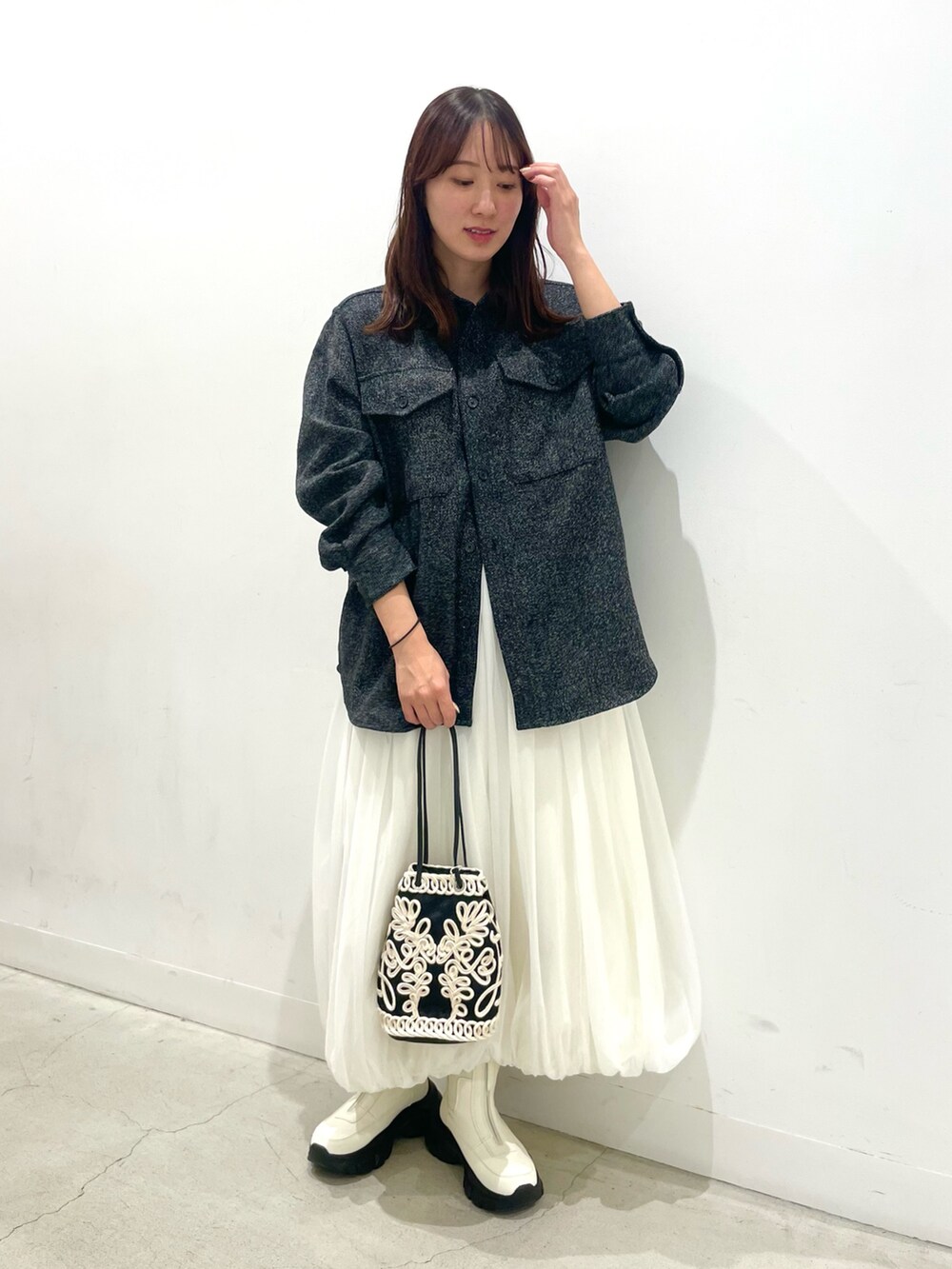 ホワイト系のその他シューズ、ブラック系のハンドバッグ、ホワイト系のスカートを着用したレディースの秋コーディネートの2枚目の写真