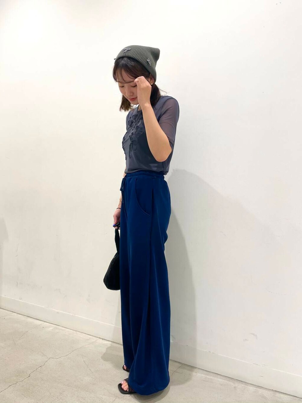 ブラック系のハンドバッグ、グレー系のTシャツ/カットソー、ブルー系のスウェットパンツを着用したレディースの夏コーディネートの4枚目の写真