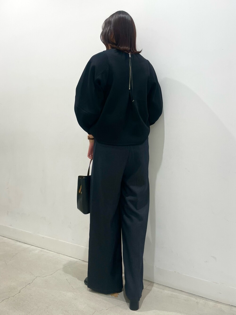 ブラック系のTシャツ/カットソー、グレー系のその他パンツ、ブラック系のブーツを着用したレディースの冬コーディネートの2枚目の写真