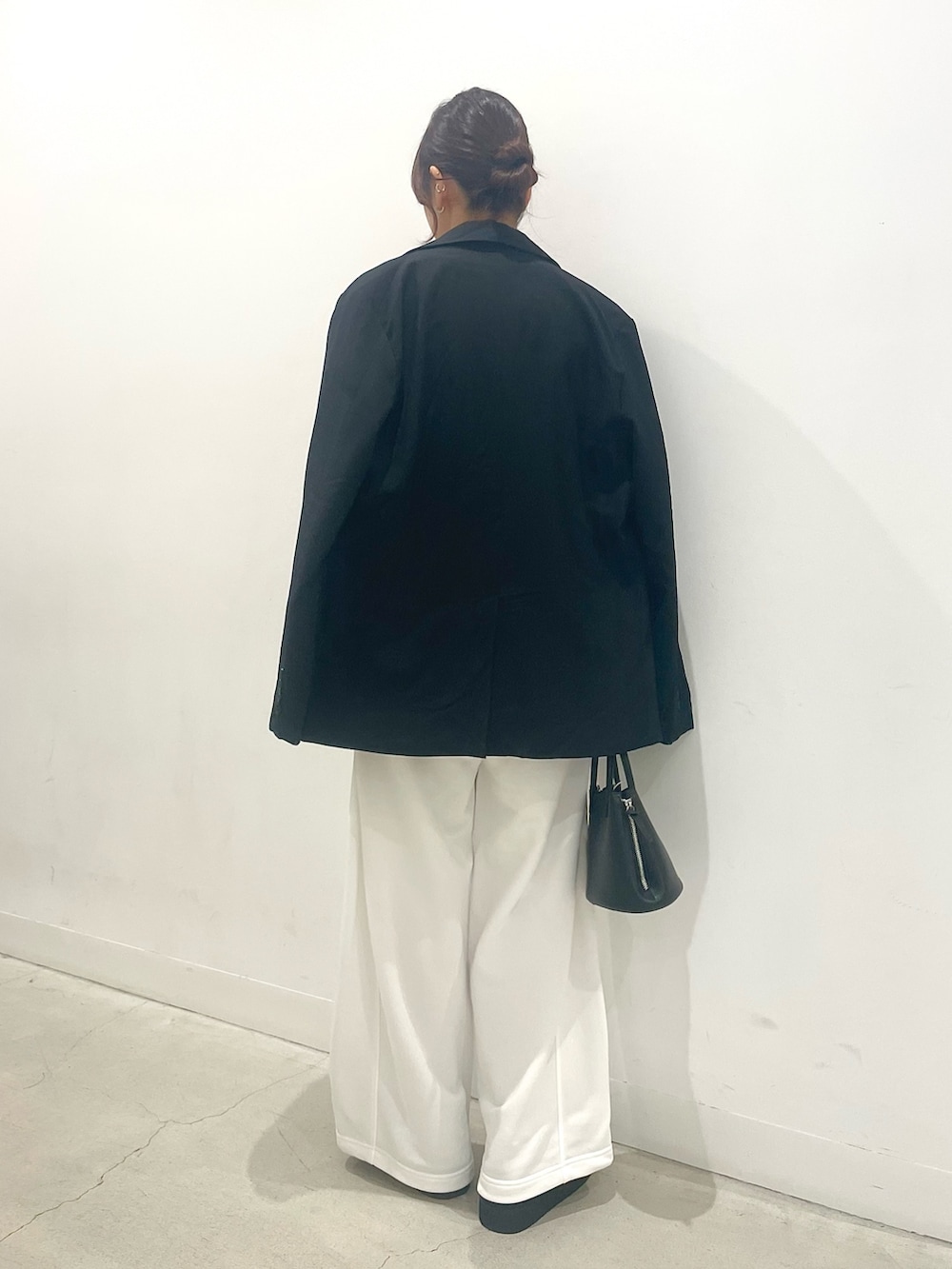 ブラック系のブーツ、ブラック系のショルダーバッグ、ブラウン系のニット/セーターを着用したレディースの秋コーディネートの3枚目の写真