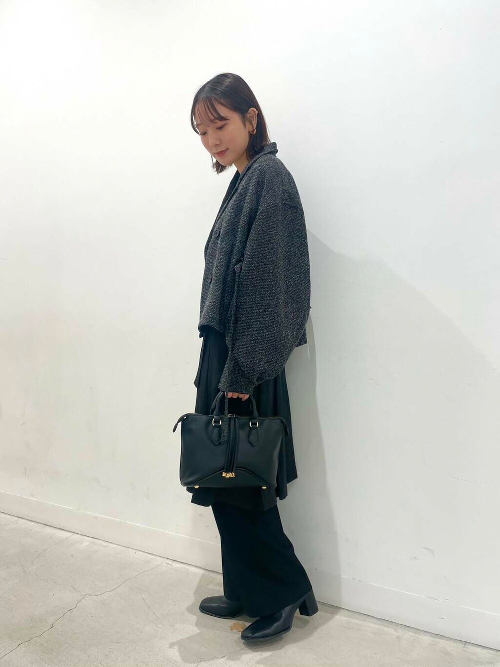 ブラック系のその他パンツ、ブラック系のボストンバッグ、ブラック系のブーツを着用したレディースの秋コーディネートの3枚目の写真