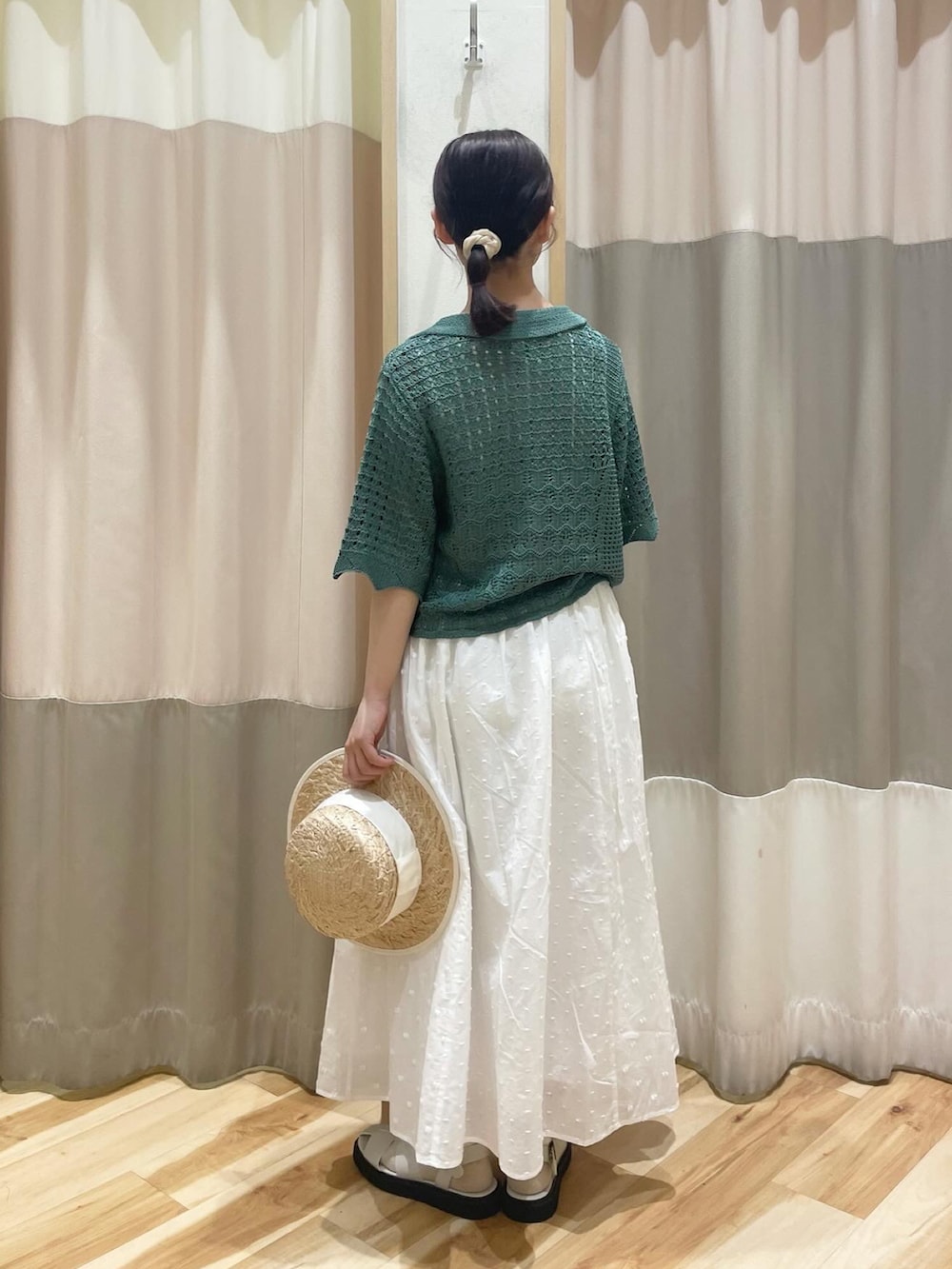グリーン系のカーディガン/ボレロ、ホワイト系のスカート、ホワイト系のサンダルを着用したレディースの春コーディネートの3枚目の写真