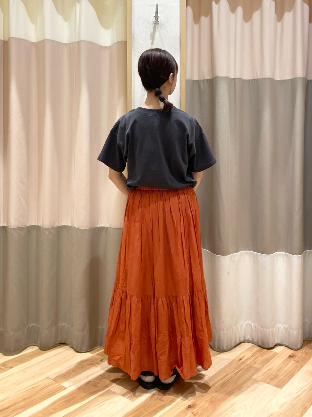 ブラウン系のサンダル、オレンジ系のスカート、グレー系のTシャツ/カットソーを着用したレディースの夏コーディネートの2枚目の写真