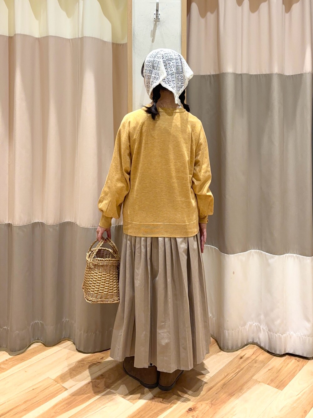 イエロー系のカーディガン/ボレロ、ベージュ系のスカート、ベージュ系のドレスシューズを着用したレディースの秋コーディネートの4枚目の写真