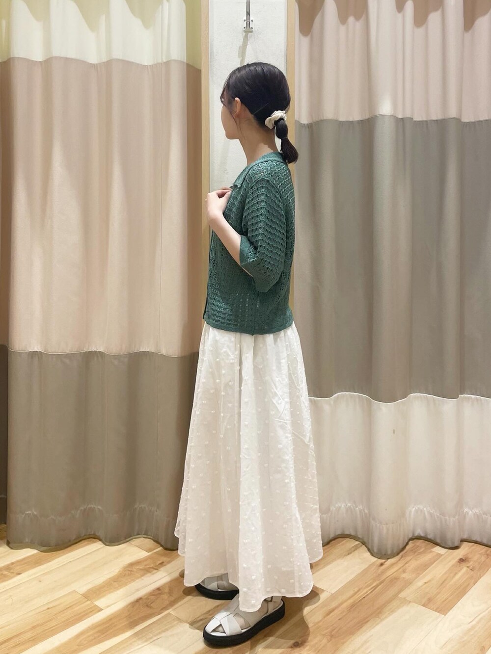 グリーン系のカーディガン/ボレロ、ホワイト系のスカート、ホワイト系のサンダルを着用したレディースの春コーディネートの2枚目の写真