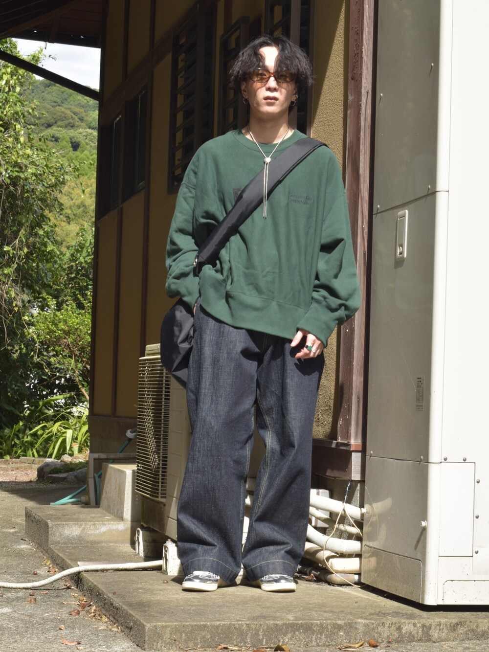 グリーン系のスウェット、ブルー系のデニムパンツ、シルバー系のスニーカーを着用したメンズの秋コーディネートの3枚目の写真