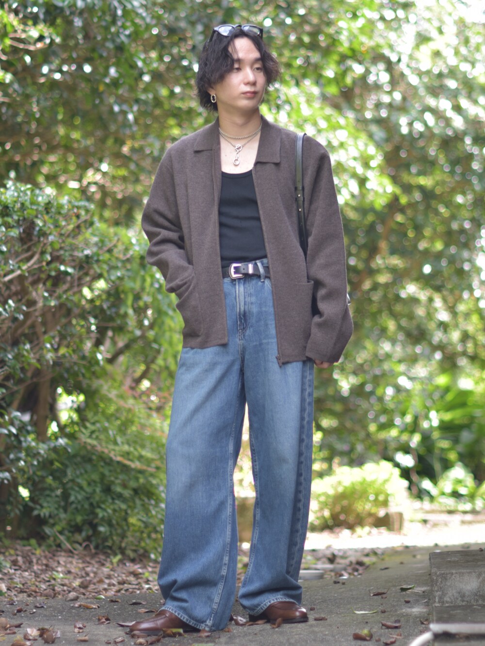 ブラック系のショルダーバッグ、ブラウン系のその他アウター、ブルー系のデニムパンツを着用したメンズの秋コーディネートの2枚目の写真