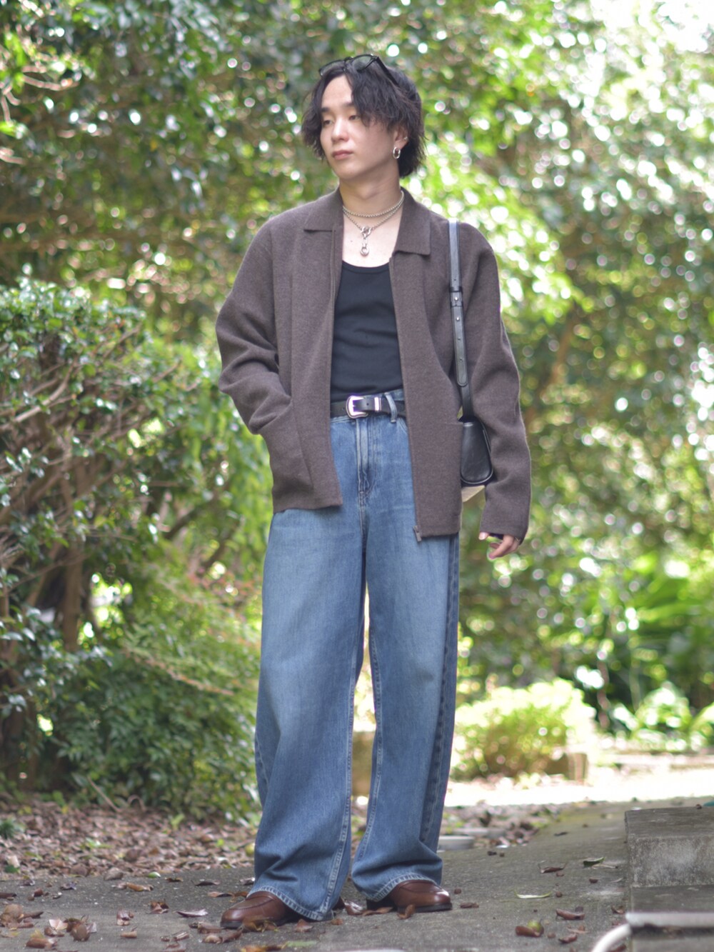 ブラック系のショルダーバッグ、ブラウン系のその他アウター、ブルー系のデニムパンツを着用したメンズの秋コーディネートの3枚目の写真